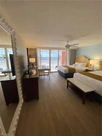 Bedroom featuring multiple windows, dark hardwood / wood-style floors, and access to outside