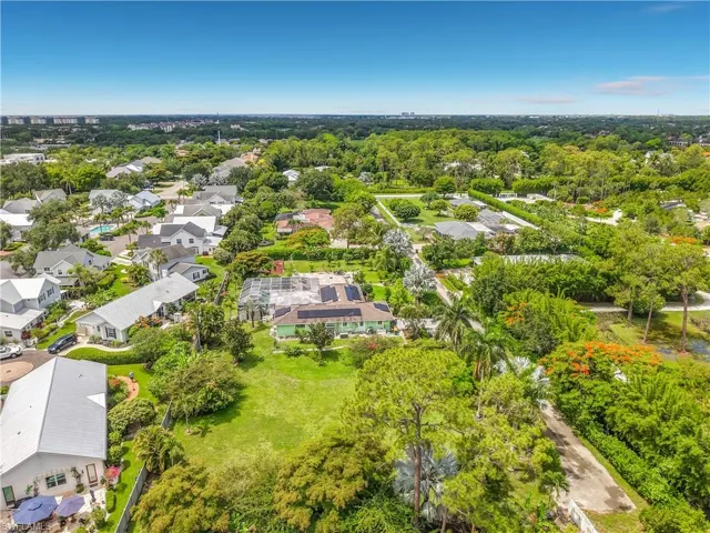 Expansive property featuring a verdant lawn, mature trees, and a spacious surrounding landscape