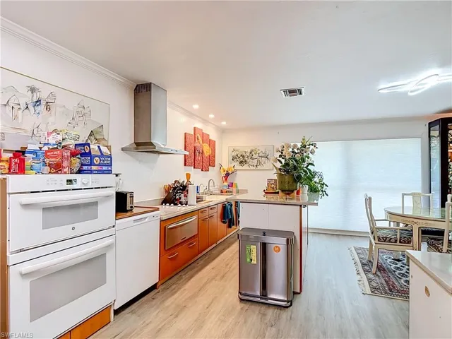 Kitchen featuring wood-finish flooring and crown molding