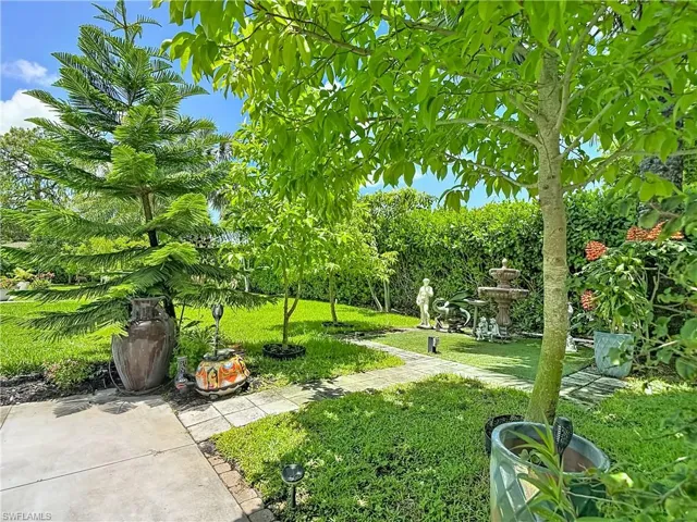 Landscaped garden featuring a tiered fountain, mature trees, and a manicured lawn