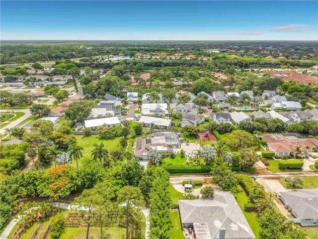 Aerial perspective showcasing a residential neighborhood with diverse architectural styles, mature trees, and landscaping