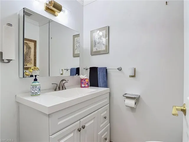 Bathroom vanity featuring a white countertop, undermount sink, and brushed nickel faucet