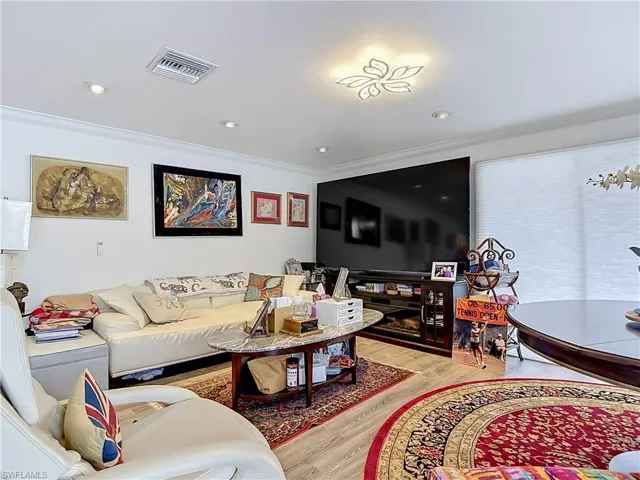 Recessed ceiling lighting, crown molding, and wood-finish flooring