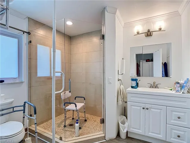 Glass-enclosed shower featuring large format wall tiles and a pebble floor