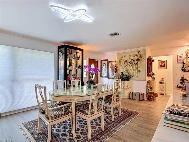 Spacious room featuring light wood-finish flooring and a contemporary circular ceiling light fixture