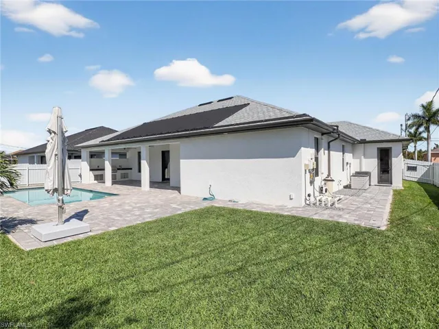 Rear view of property with a fenced backyard, a patio, and stucco siding