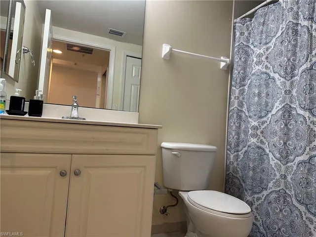 Bathroom featuring toilet, vanity, and walk in shower