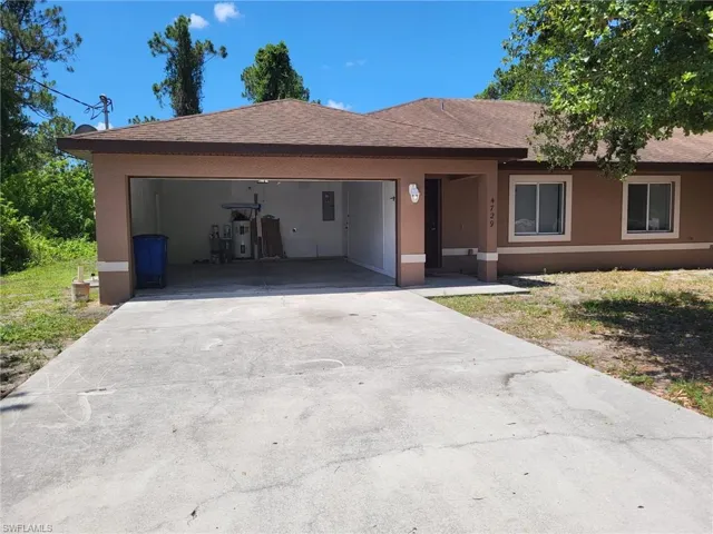 View of front of home featuring a shingled roof, concrete driveway, an attached garage, and stucco siding