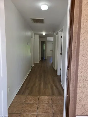 Hall featuring dark wood-style floors and baseboards