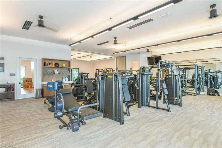 Workout area with light colored carpet and ceiling fan
