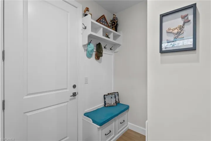 Mudroom with light wood-style floors and baseboards