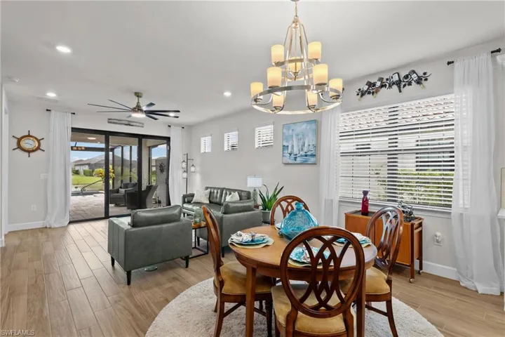 Dining area with light wood-style floors, ceiling fan, a chandelier, and recessed lighting