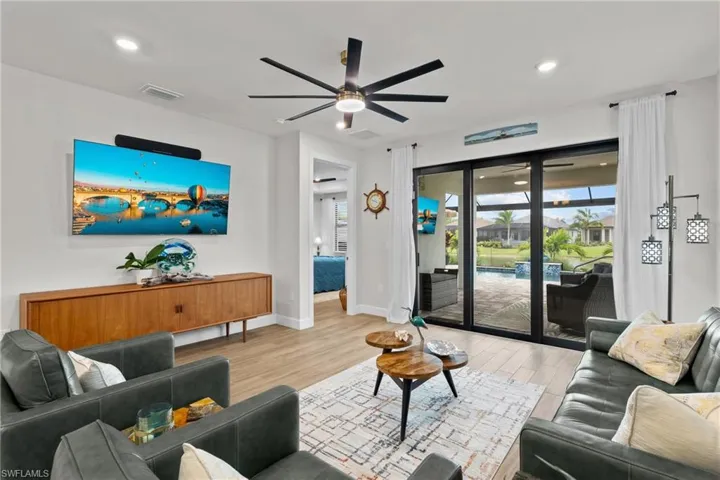 Living room featuring light wood-type flooring, plenty of natural light, a ceiling fan, and recessed lighting