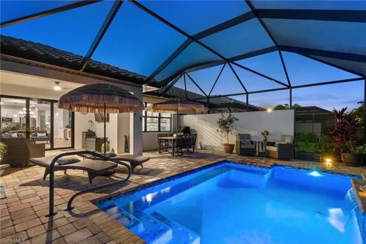 Outdoor pool with glass enclosure, a patio, and a sunroom
