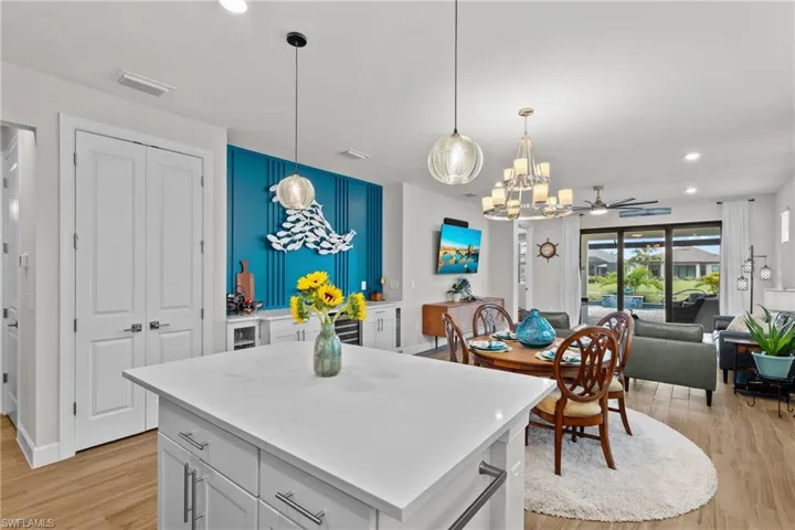 Kitchen with light wood-type flooring, a center island, hanging light fixtures, open floor plan, and recessed lighting