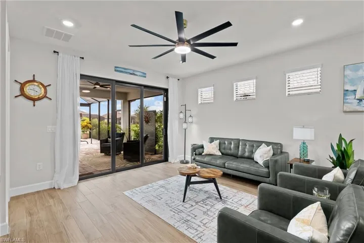 Living room featuring plenty of natural light, light wood finished floors, recessed lighting, and a ceiling fan