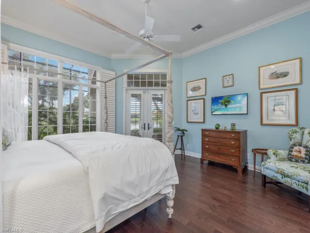 Primary bedroom with walk out to lanai, crown molding and french doors