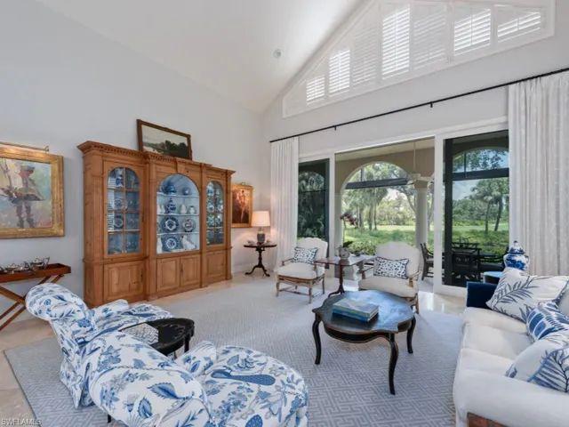 Living room featuring high vaulted ceiling and light tile floors