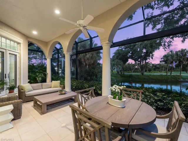 Lanai at dusk featuring outdoor lounge area, ceiling fan, and a water view