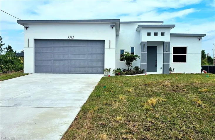 View of front facade featuring stucco siding, concrete driveway, a front lawn, and an attached garage