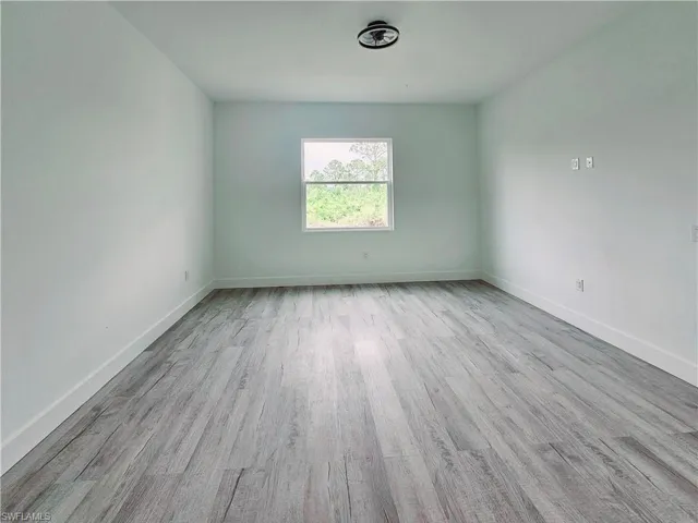 Spare room featuring baseboards and wood finished floors