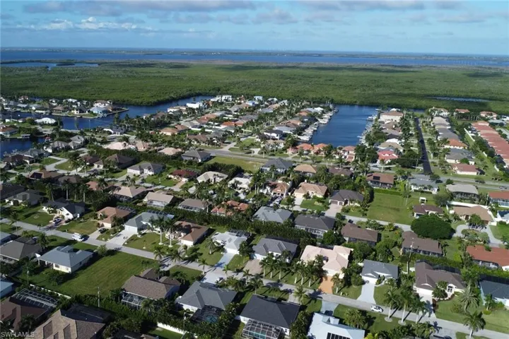 Aerial overview of property's location featuring a large body of water and nearby suburban area