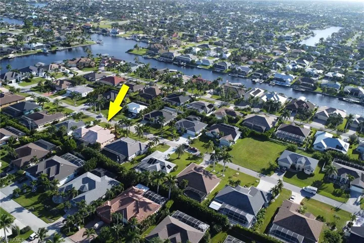 Aerial view of property and surrounding area featuring a nearby body of water and nearby suburban area