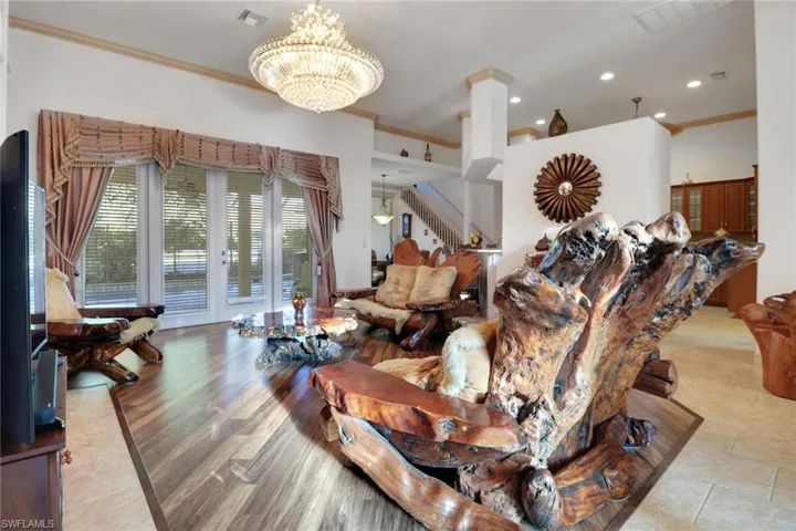 Living room featuring ornamental molding, recessed lighting, stairway, and french doors