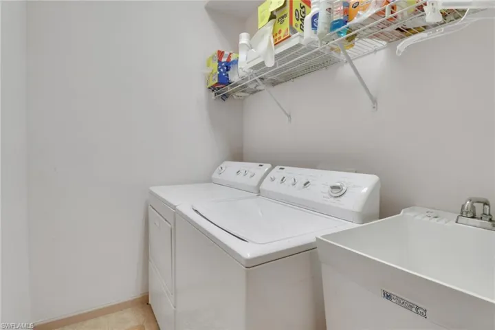 Laundry room featuring washing machine and dryer and baseboards