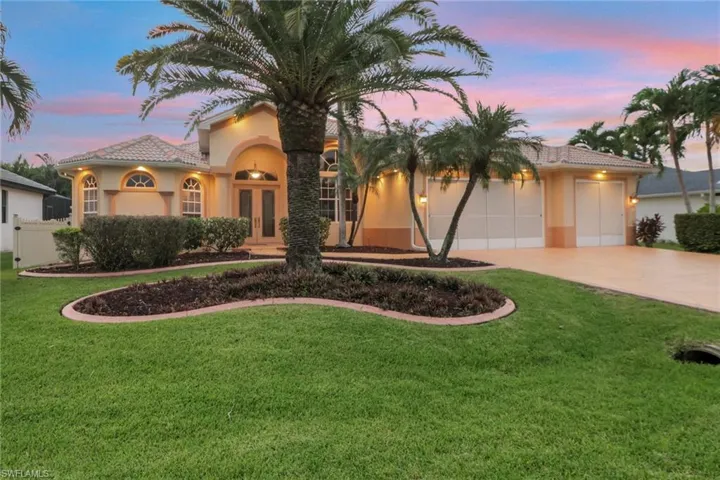 Mediterranean / spanish-style house with stucco siding, a front lawn, a garage, french doors, and driveway