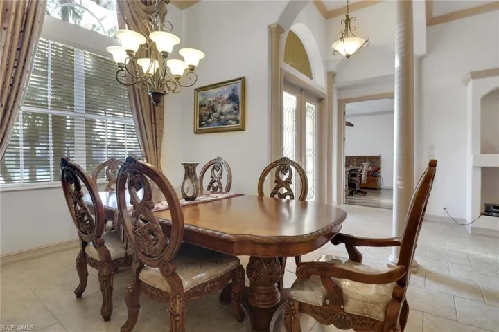 Dining space featuring a chandelier, arched walkways, and light tile patterned floors