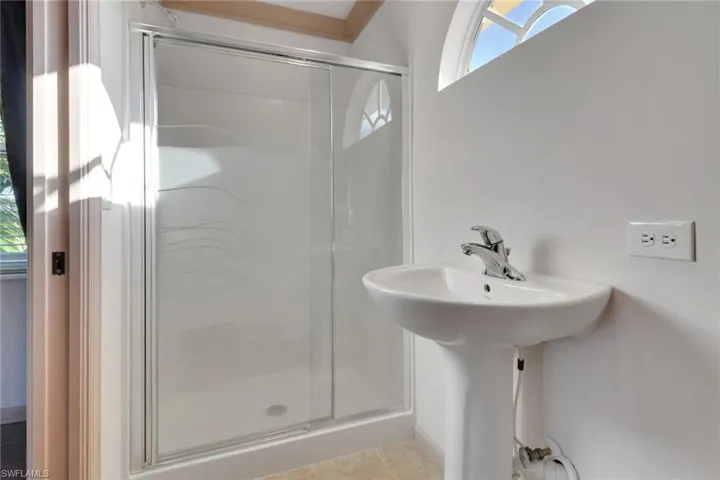 Full bath featuring a shower stall and light tile patterned flooring