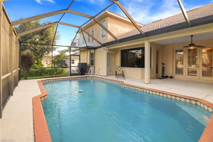 Outdoor pool with a patio area, a sunroom, ceiling fan, and a lanai