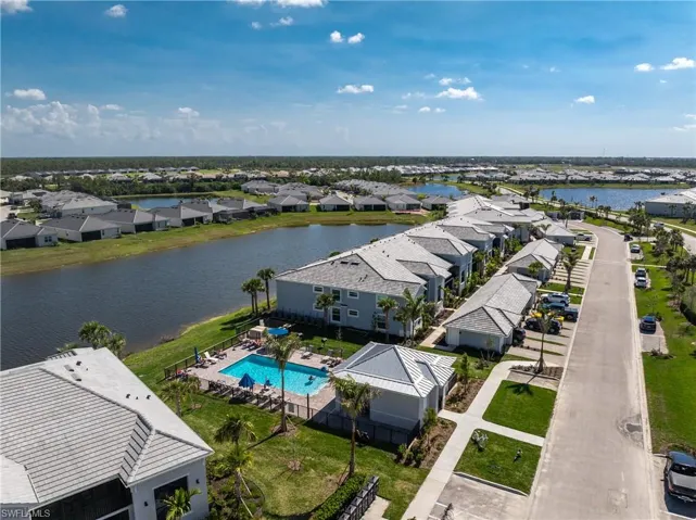 Aerial perspective of suburban area featuring a large body of water and a pool area