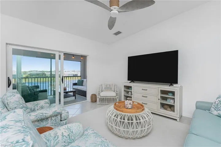 Living room with light tile patterned flooring and ceiling fan