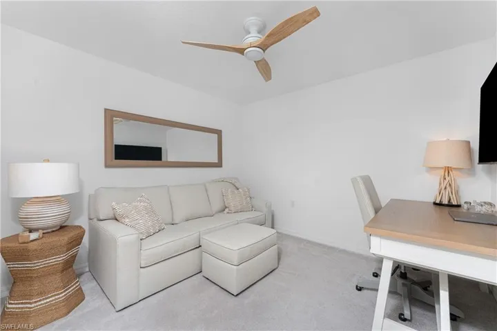 Home office featuring light carpet and a ceiling fan