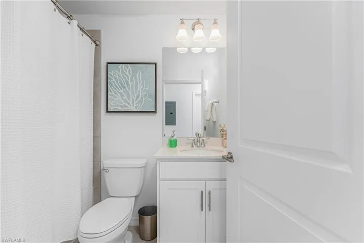 Full bathroom featuring curtained shower and vanity