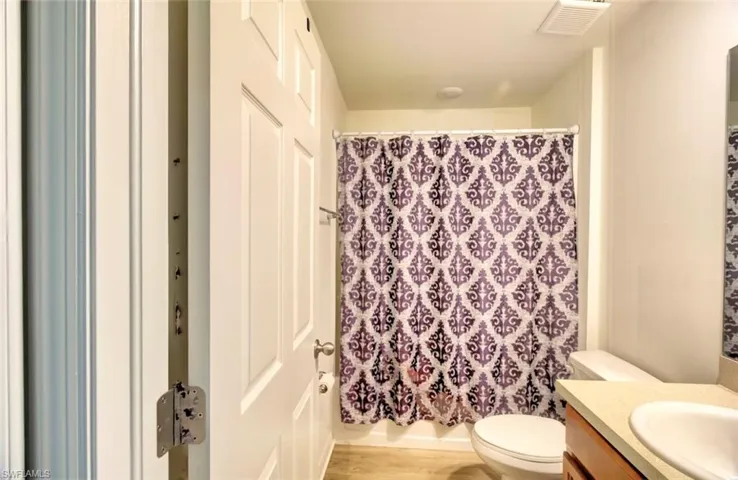 Bathroom with visible vents, wood finished floors, toilet, and vanity