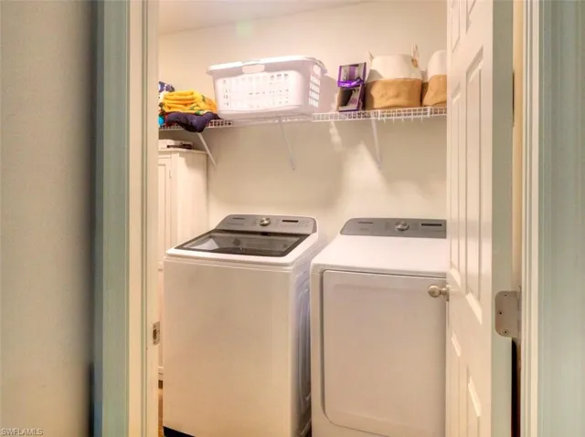 Clothes washing area featuring washer and dryer and laundry area