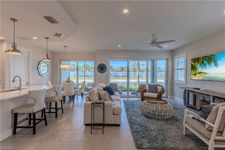 Family room with ceiling fan, light tile patterned floors & recessed lighting