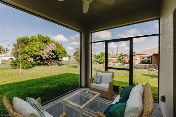 Sunroom with a ceiling fan and a residential view