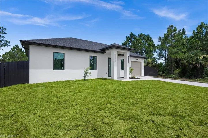 Contemporary single-story residence with a stucco exterior, dark shingle roof, and a two-car garage