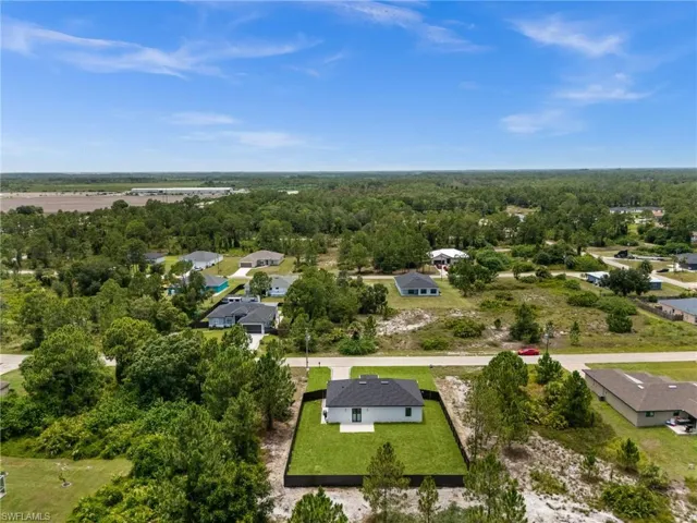 Contemporary single-story home featuring a dark shingle roof and a light-colored exterior