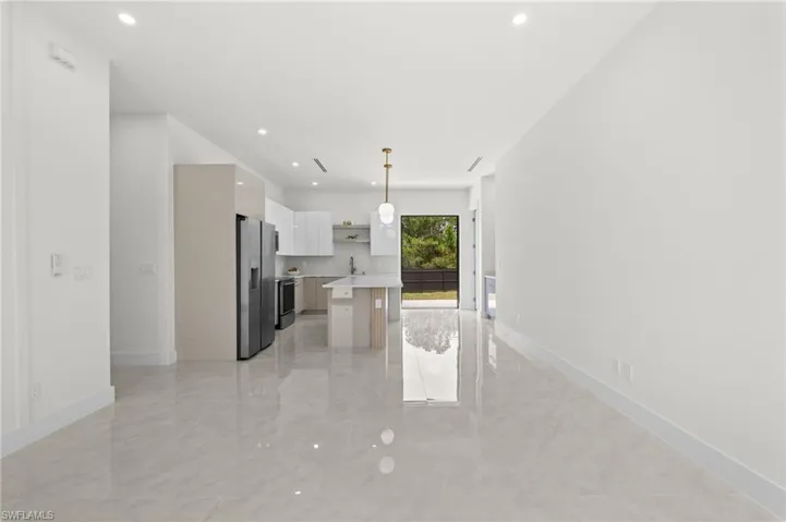 Open-concept interior featuring light tile flooring and recessed lighting