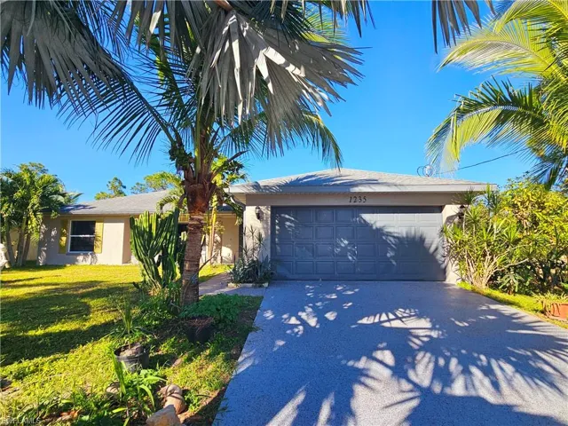 View of front of home featuring a front yard and a garage