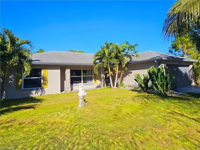 Ranch-style home with a garage and a front lawn