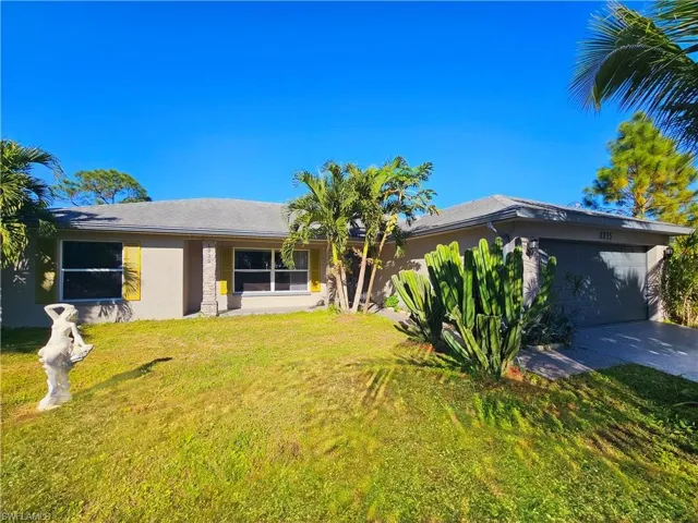View of front facade with a garage and a front lawn