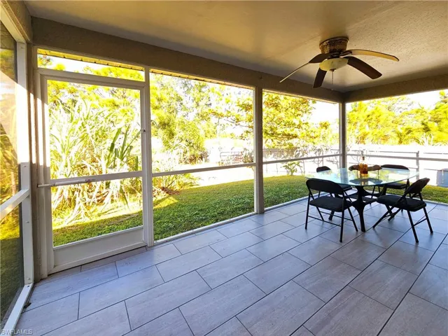 Unfurnished sunroom featuring ceiling fan