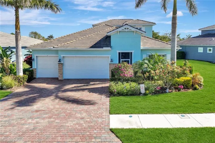 View of front of house with an attached garage, stone siding, decorative driveway, stucco siding, and a front yard