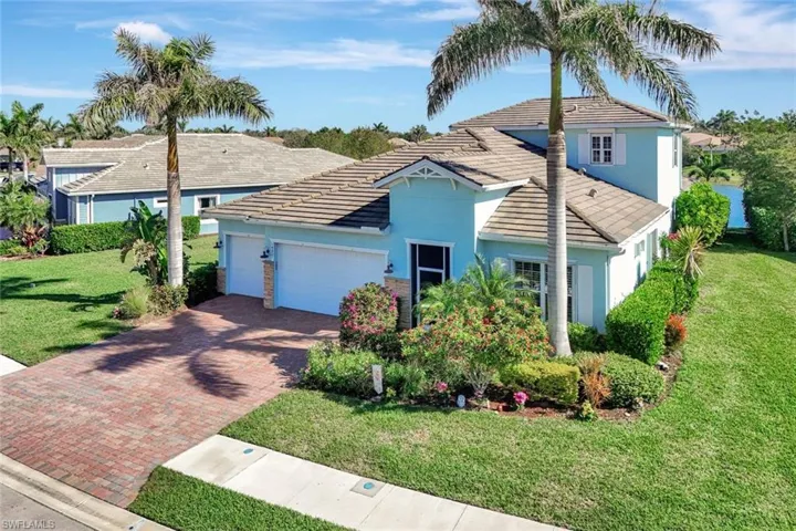 View of front of home with a front yard, decorative driveway, an attached garage, and stucco siding